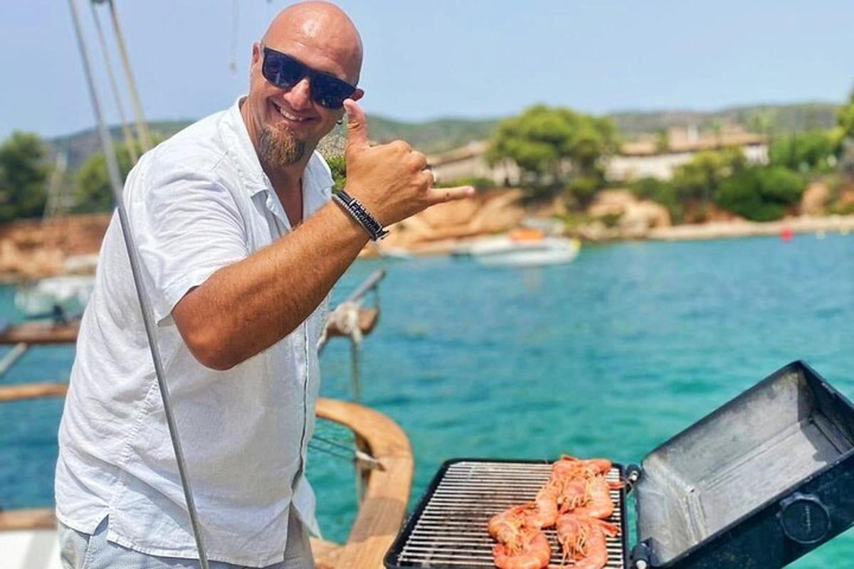 Ένας άντρας που στέκεται δίπλα σε μια ψησταριά με κρέας