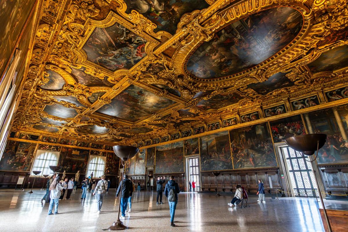 lidé procházející se kolem Versaillesského paláce s obrazy na stropech