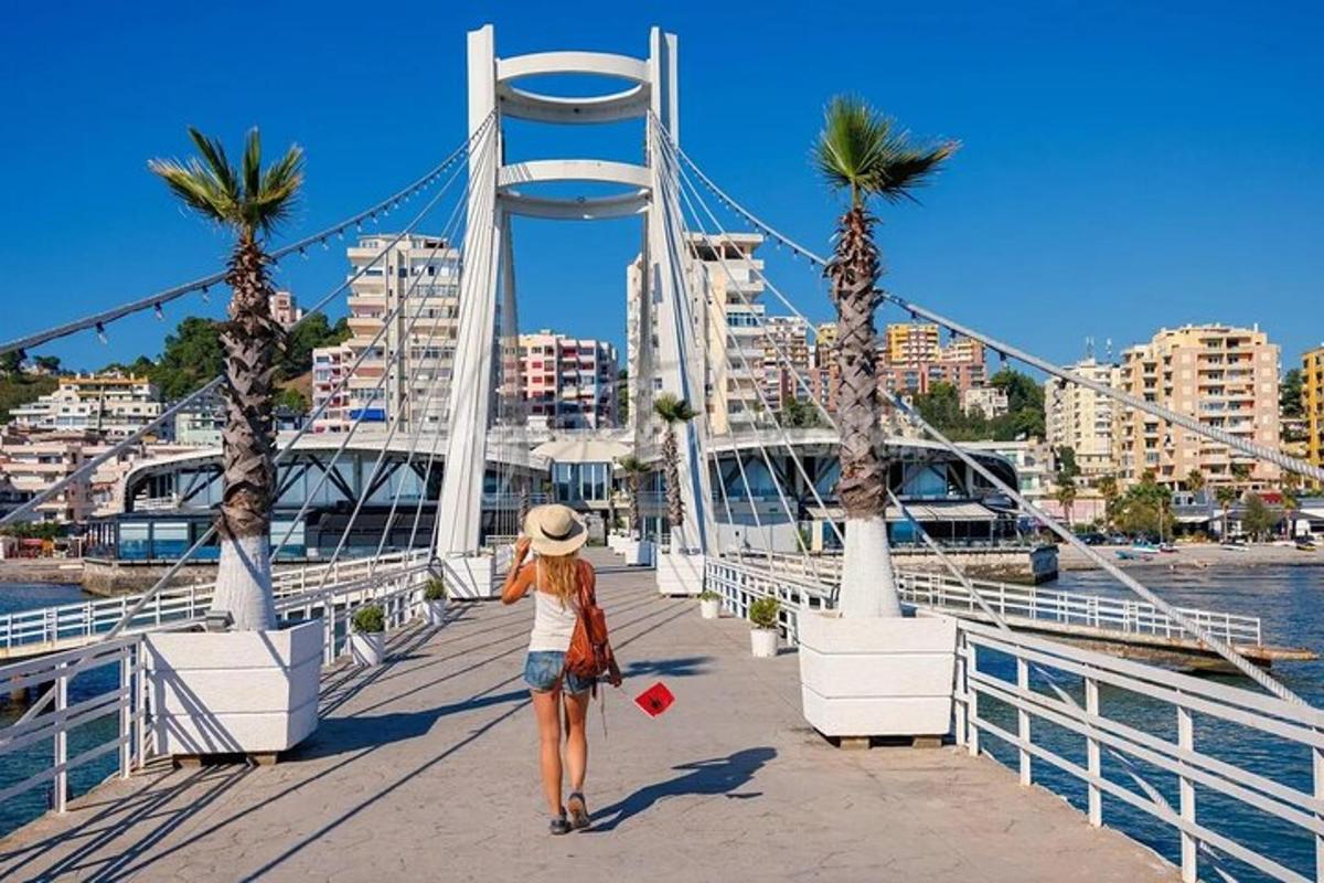 una donna che cammina su un ponte con palme