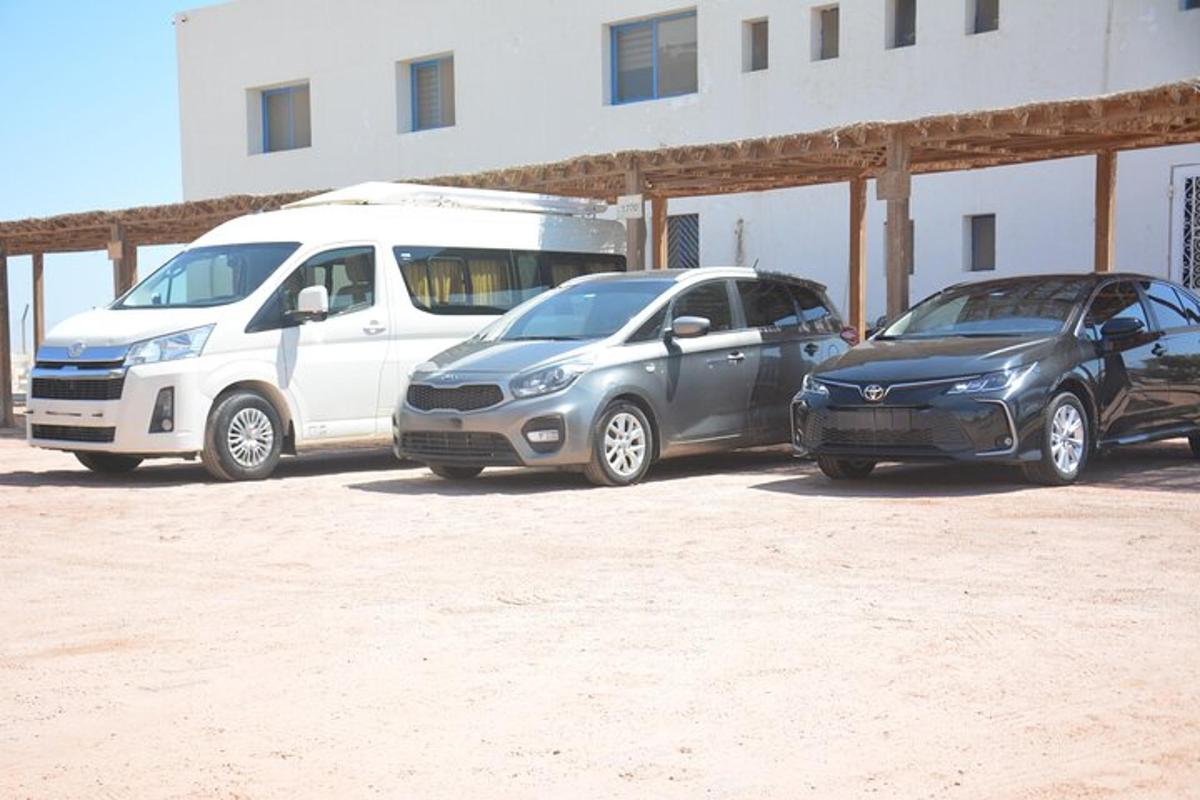 tres cotxes aparcats en un aparcament al costat d'un edifici