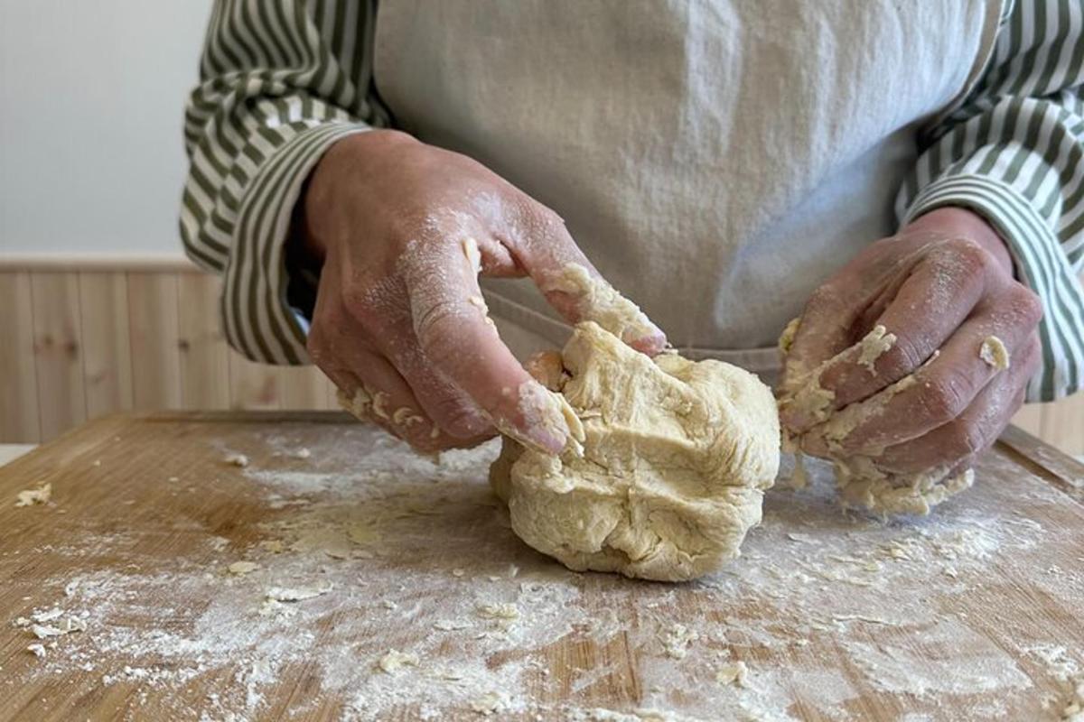 a person kneading a piece of dough on a table