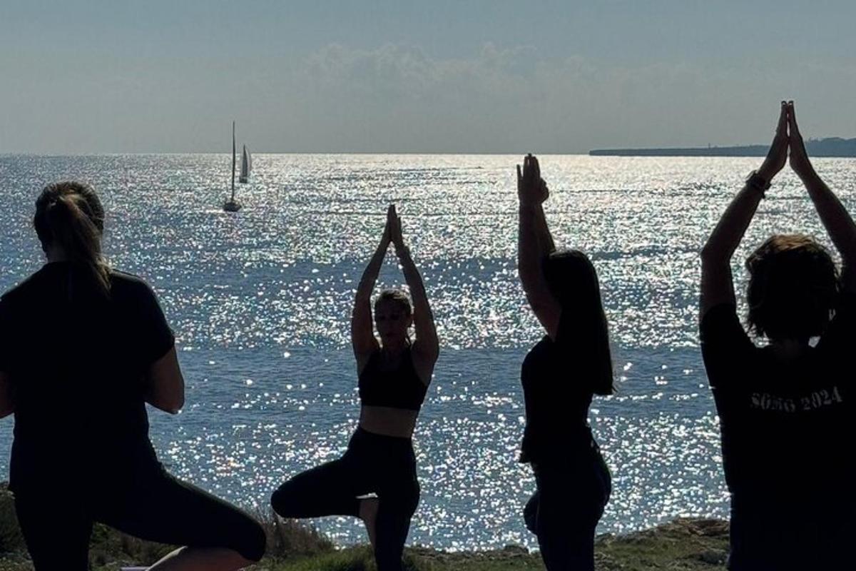 en gruppe kvinner som gjør yoga ved vannet
