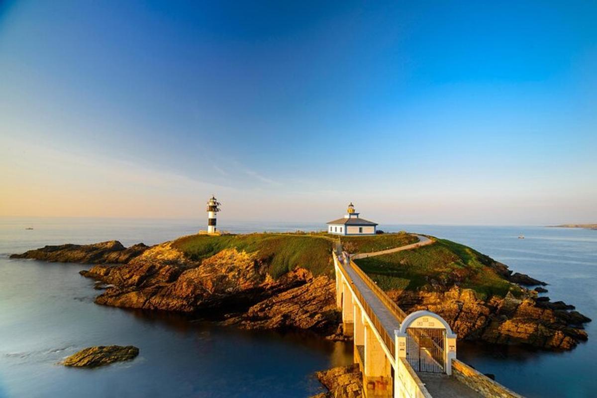 a lighthouse on an island in the ocean with a bridge