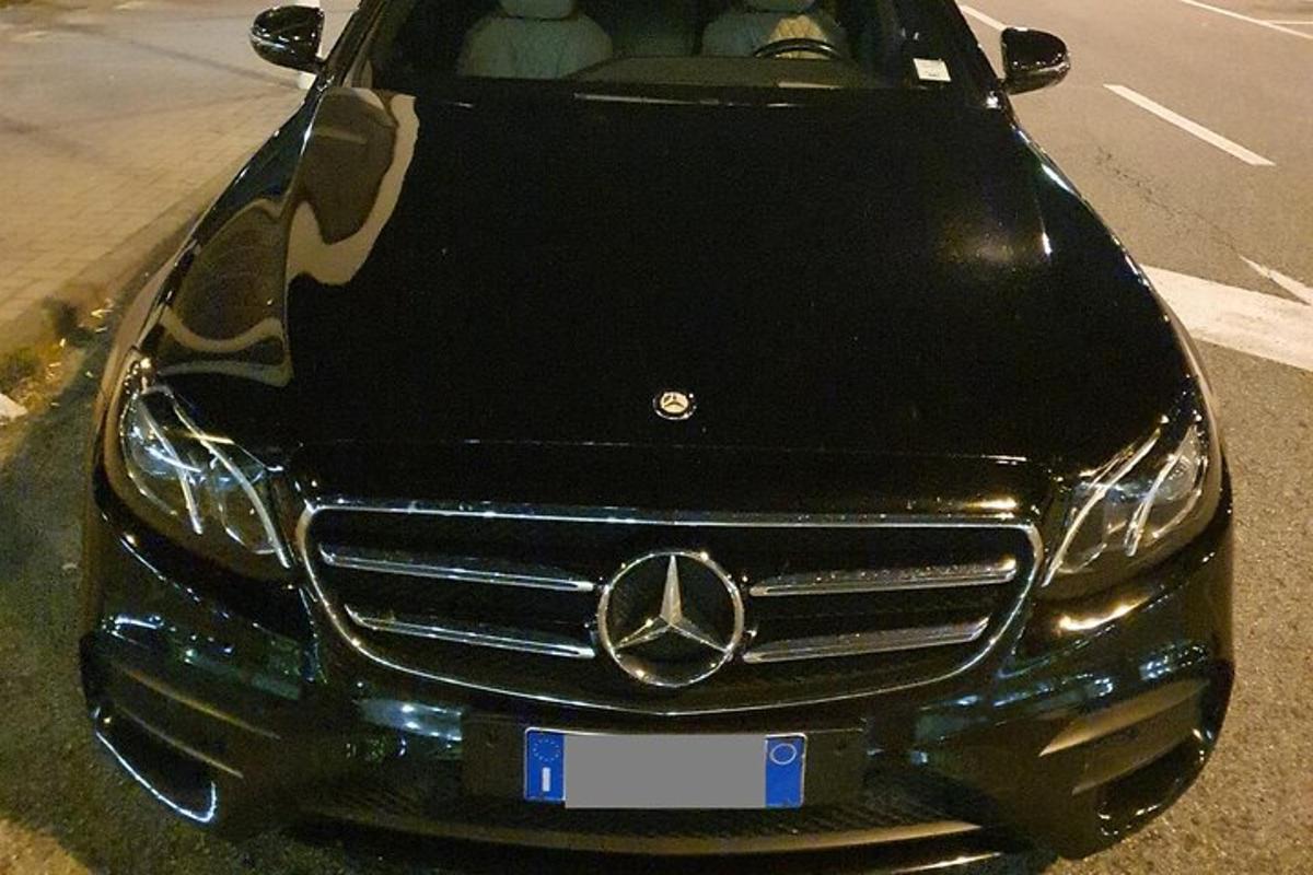um carro Mercedes Benz estacionado na beira de uma estrada