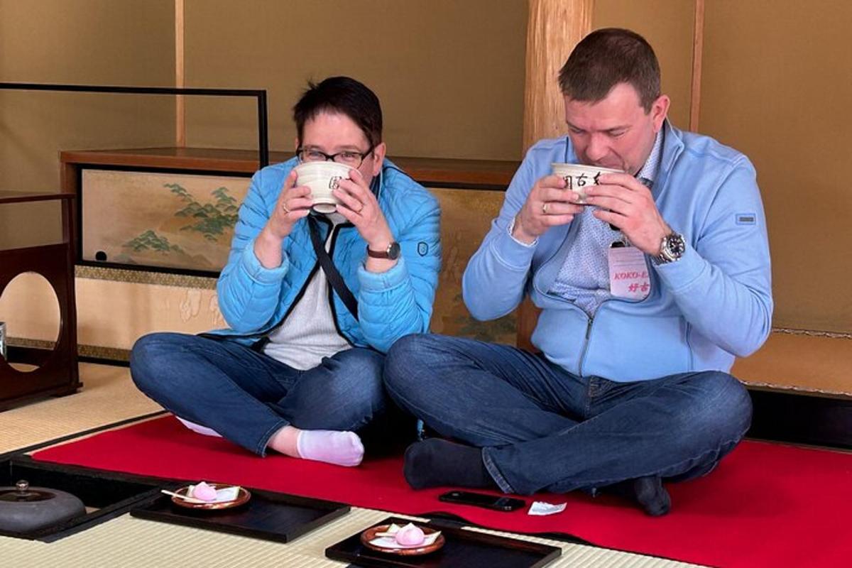 Két férfi ül a földön, fényképezget a mobiltelefonjával