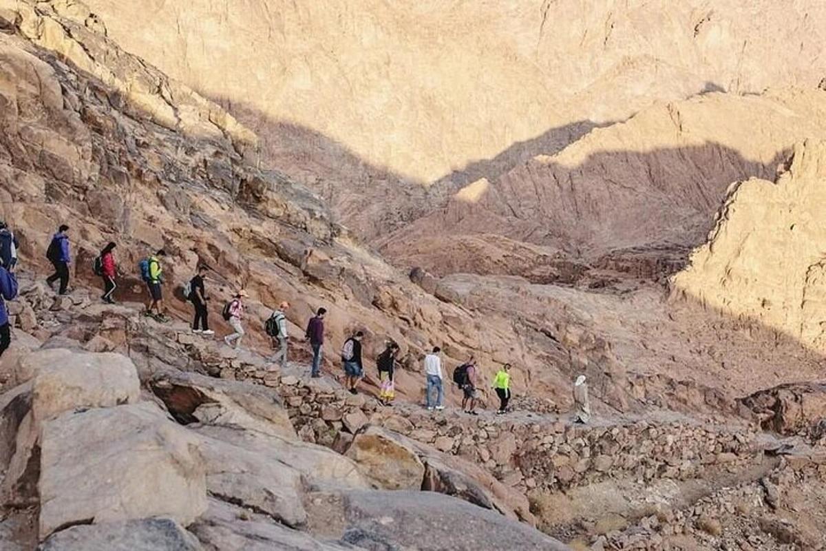 un grup de persones caminant per una muntanya rocosa