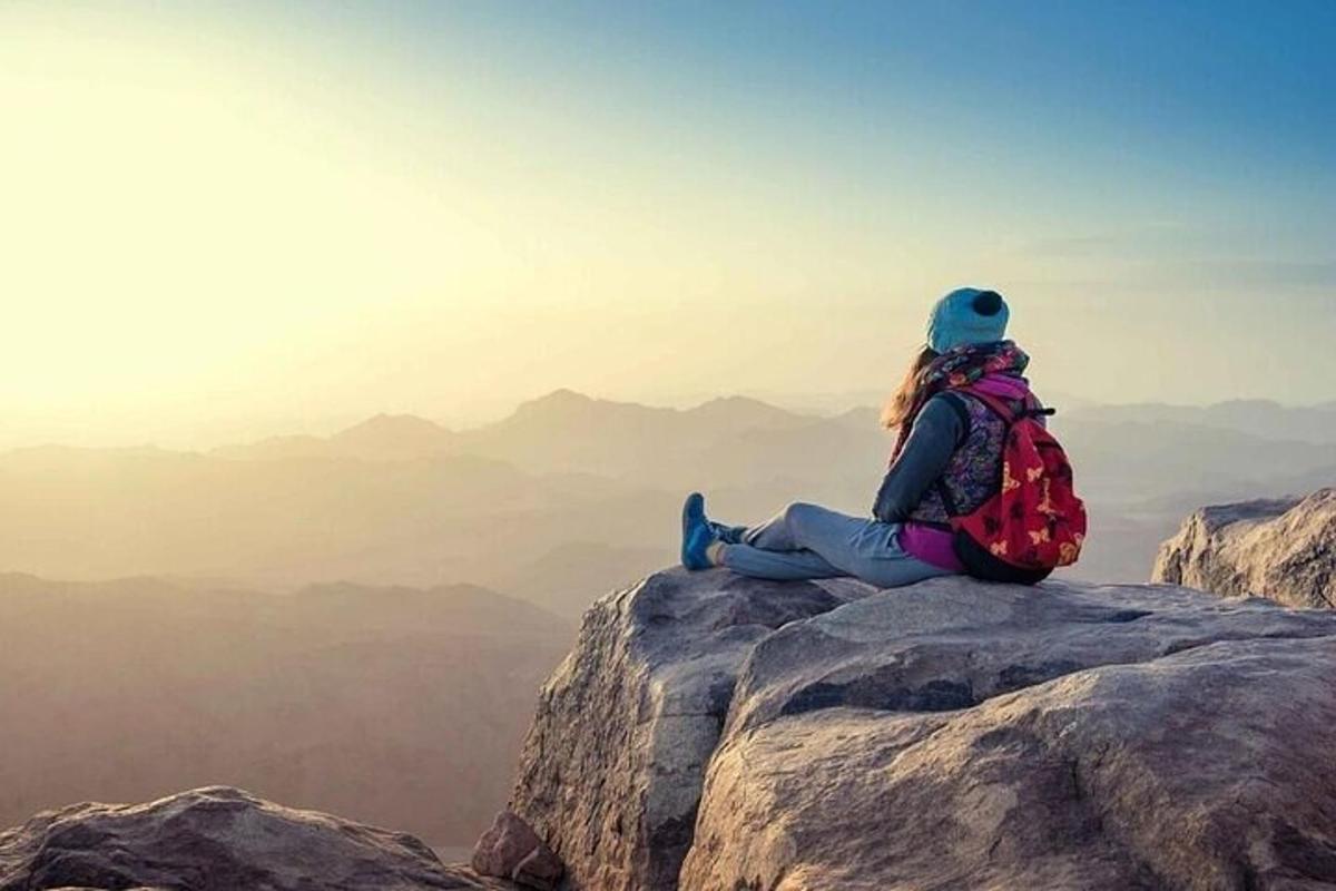 una donna seduta in cima a una montagna