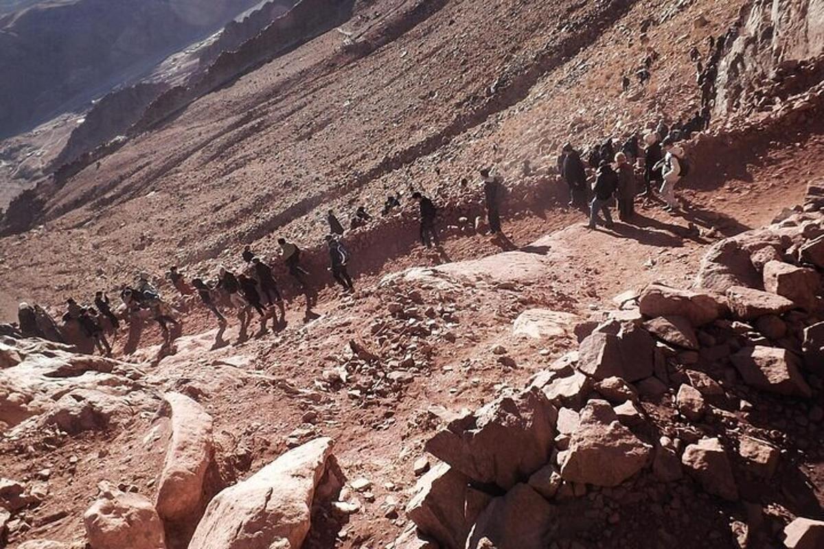 a group of people walking on a rocky mountain