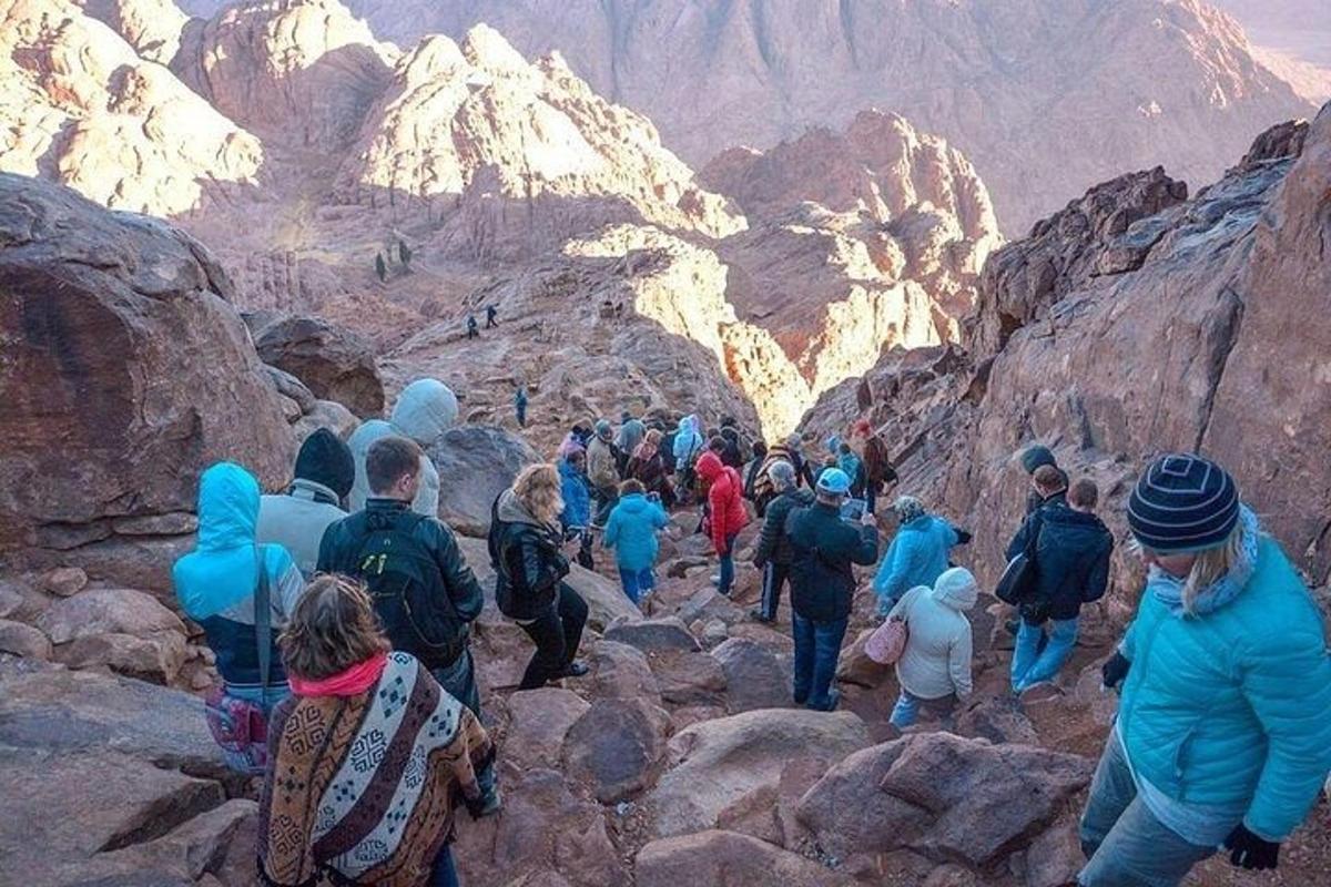 a group of people walking on a rocky mountain