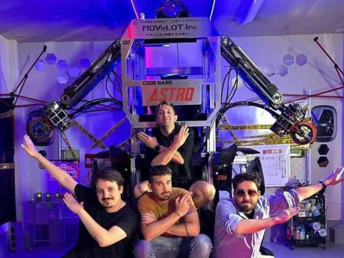 a group of men posing for a picture in front of a machine