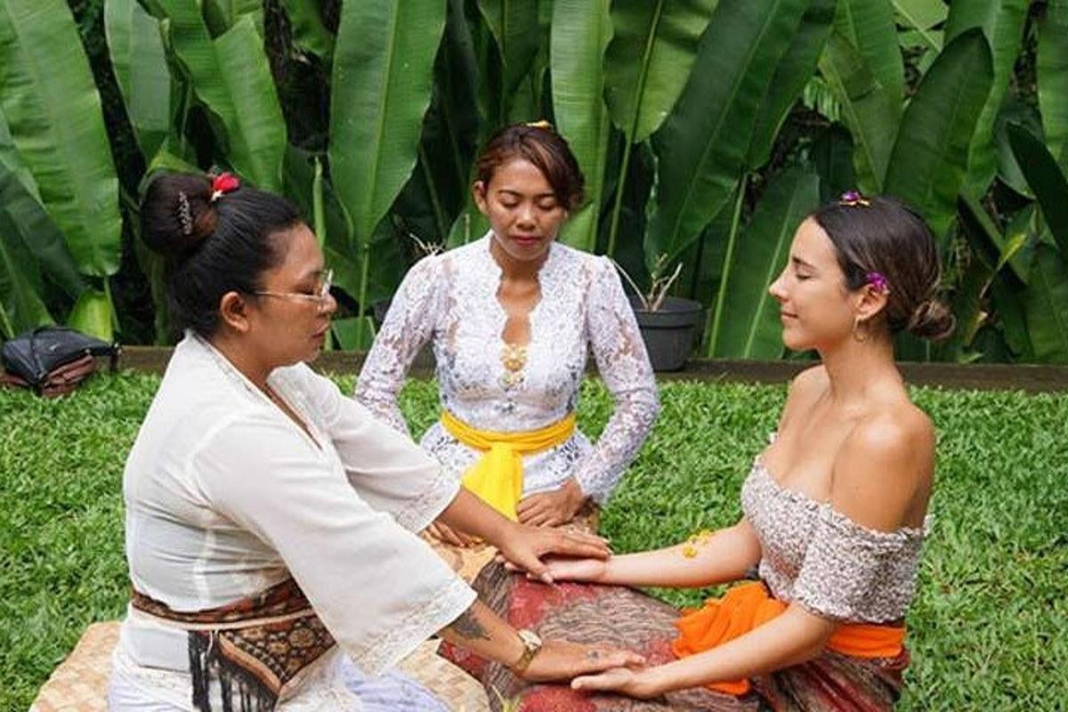 sekelompok tiga wanita duduk di atas rumput