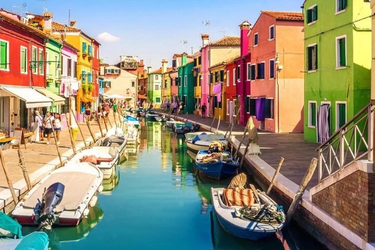 un gruppo di barche in un canale con edifici colorati