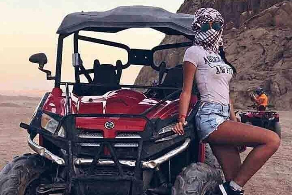 امرأة تجلس على ظهر مركبة رباعية الدفع في الصحراء