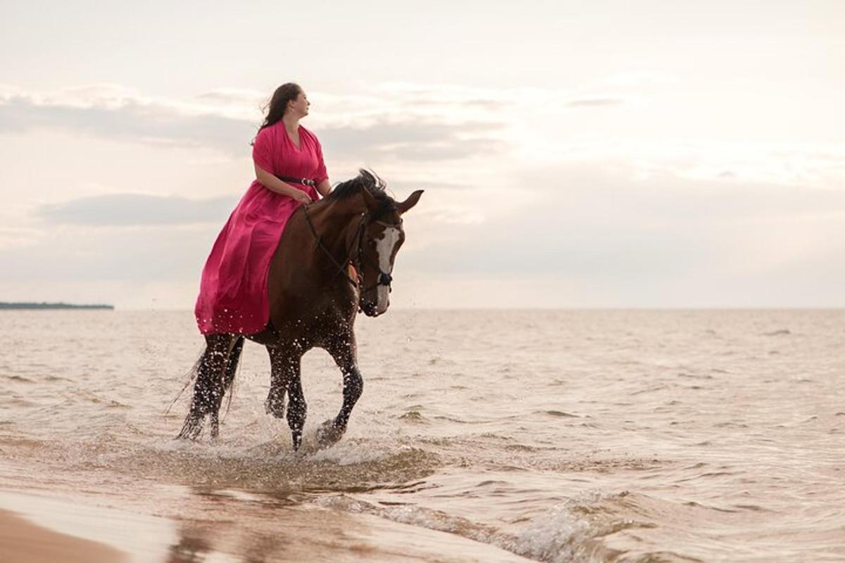 una donna in un vestito rosa a cavallo nell'acqua