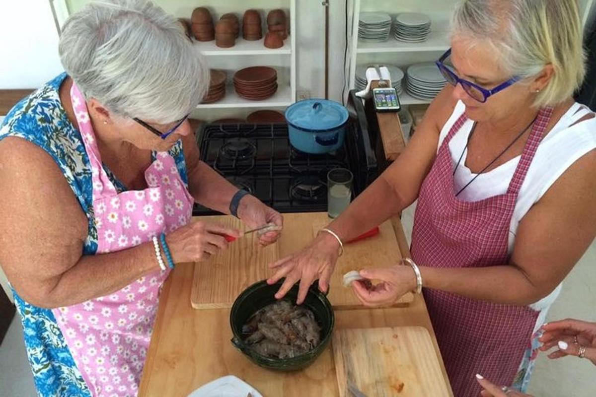 due donne anziane che preparano il cibo in una ciotola su un bancone