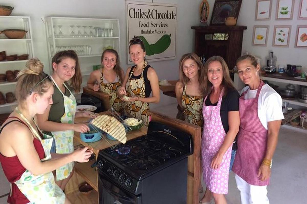 un gruppo di donne in piedi in una cucina che preparano il cibo