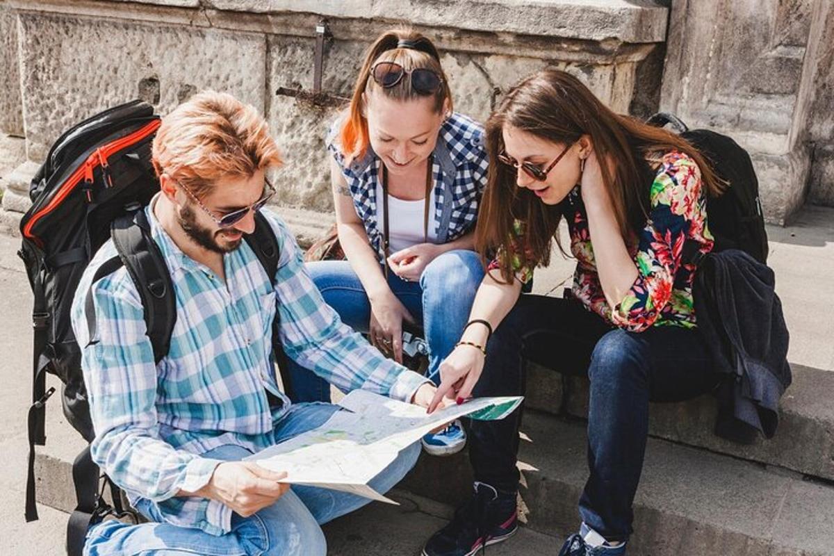 tři lidé sedící na schodech a dívající se na mapu