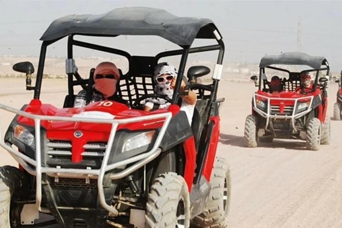 dua orang menunggang atv di padang pasir