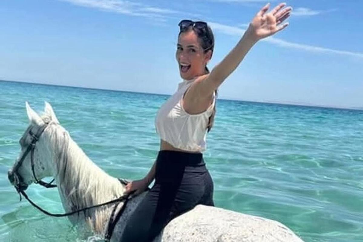 امرأة تركب حصانًا أبيض في المحيط