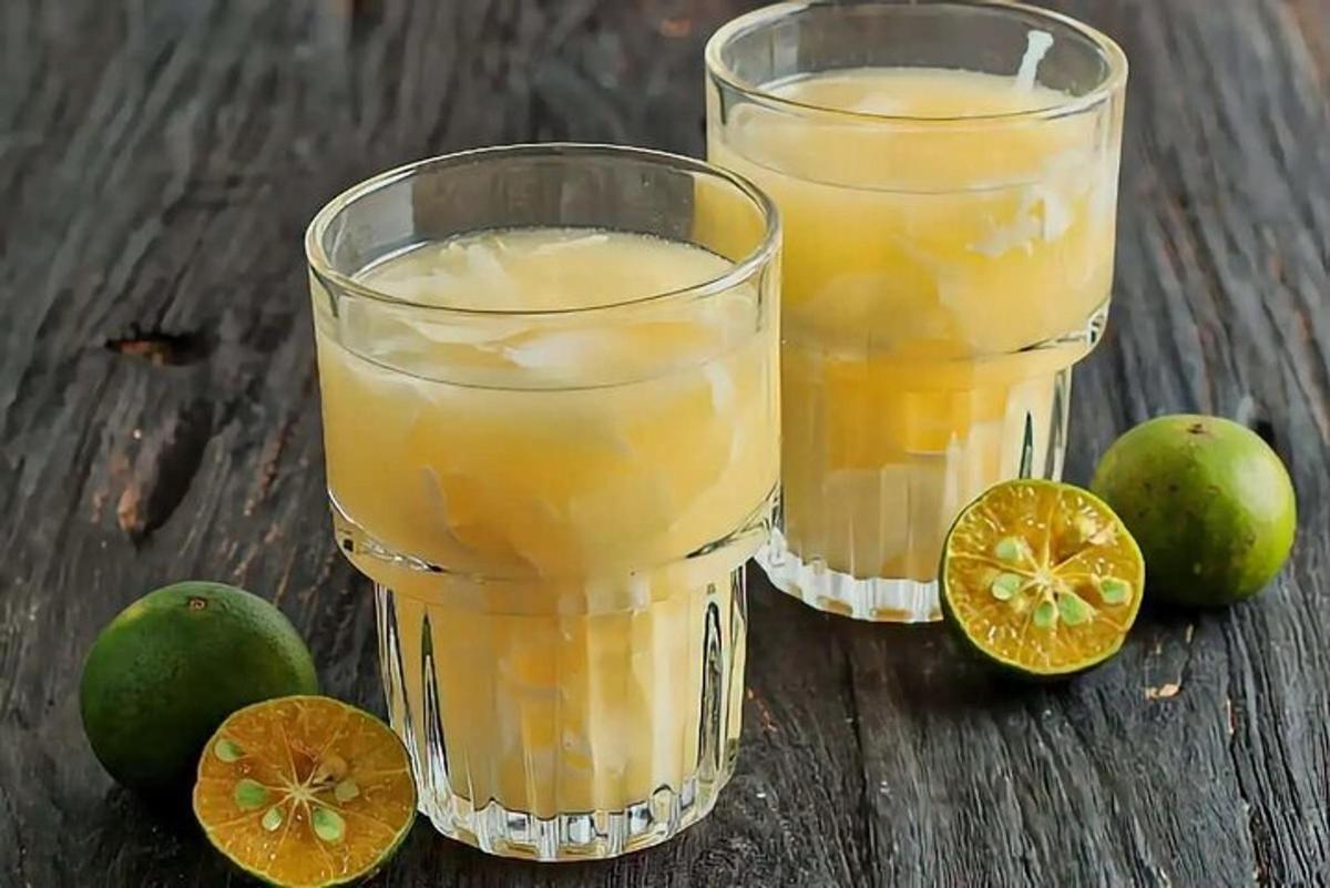 zwei Gläser Orangensaft und Limetten auf einem Tisch