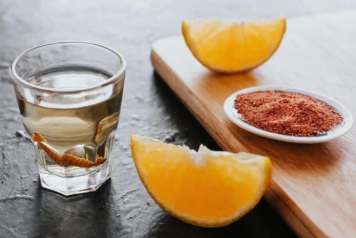 Un vaso de agua y una rodaja de naranja en una tabla de cortar