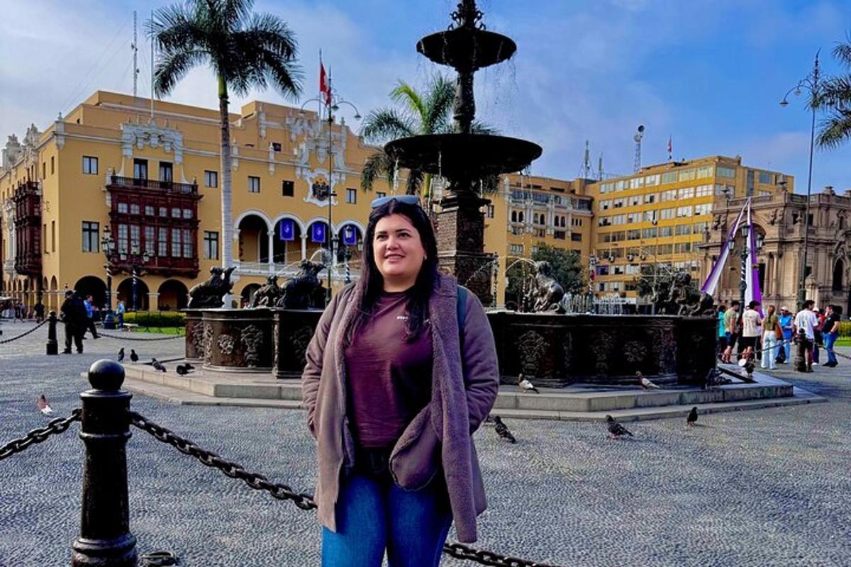 une femme se tient devant une fontaine