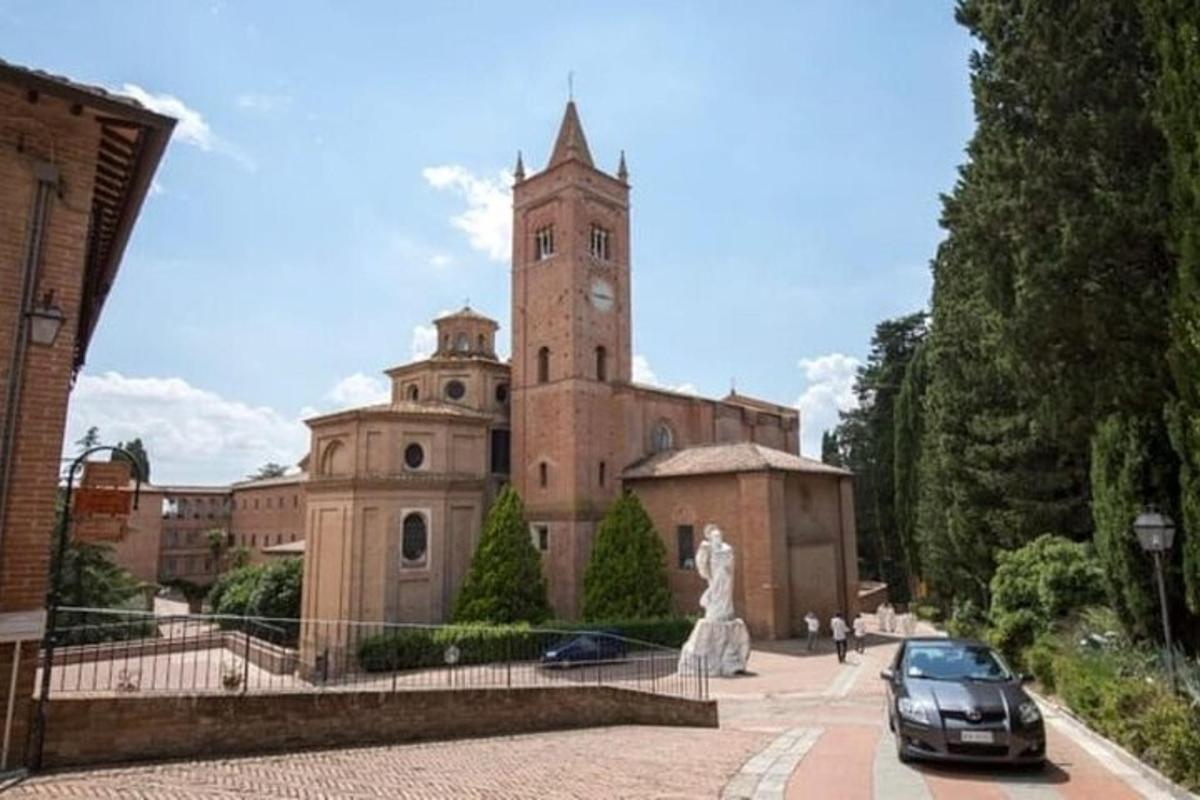 un edificio con una torre dell'orologio con un'auto parcheggiata di fronte
