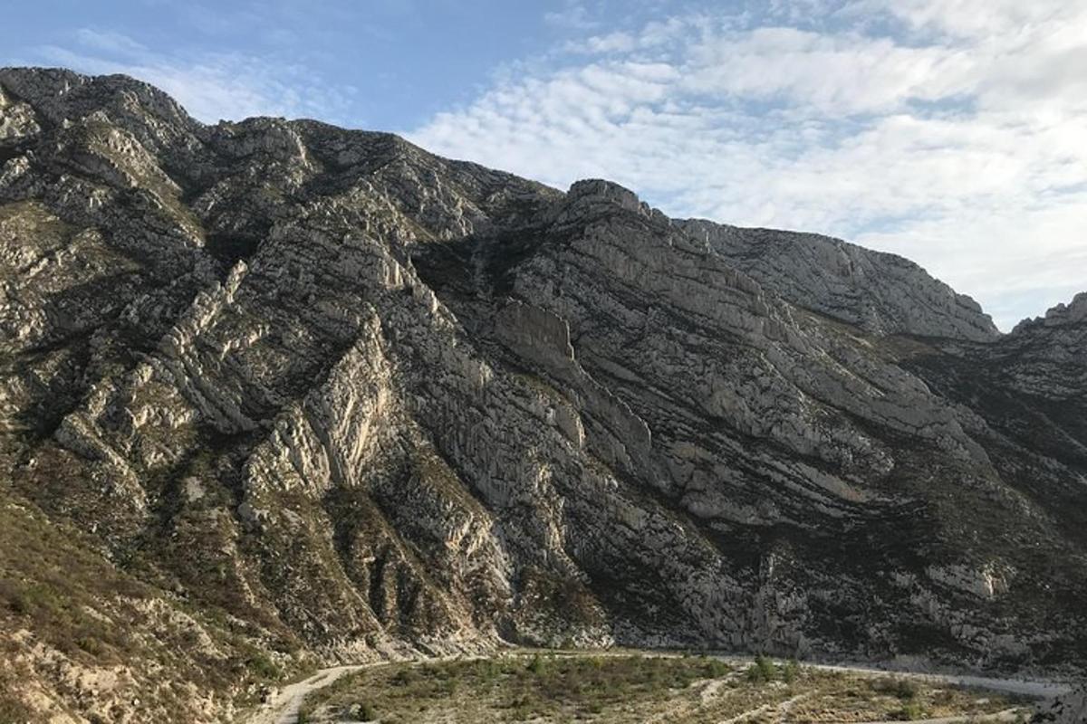 a rocky mountain with a road in front of it