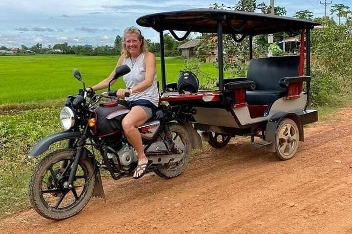 una donna in sella a una motocicletta con un golf cart