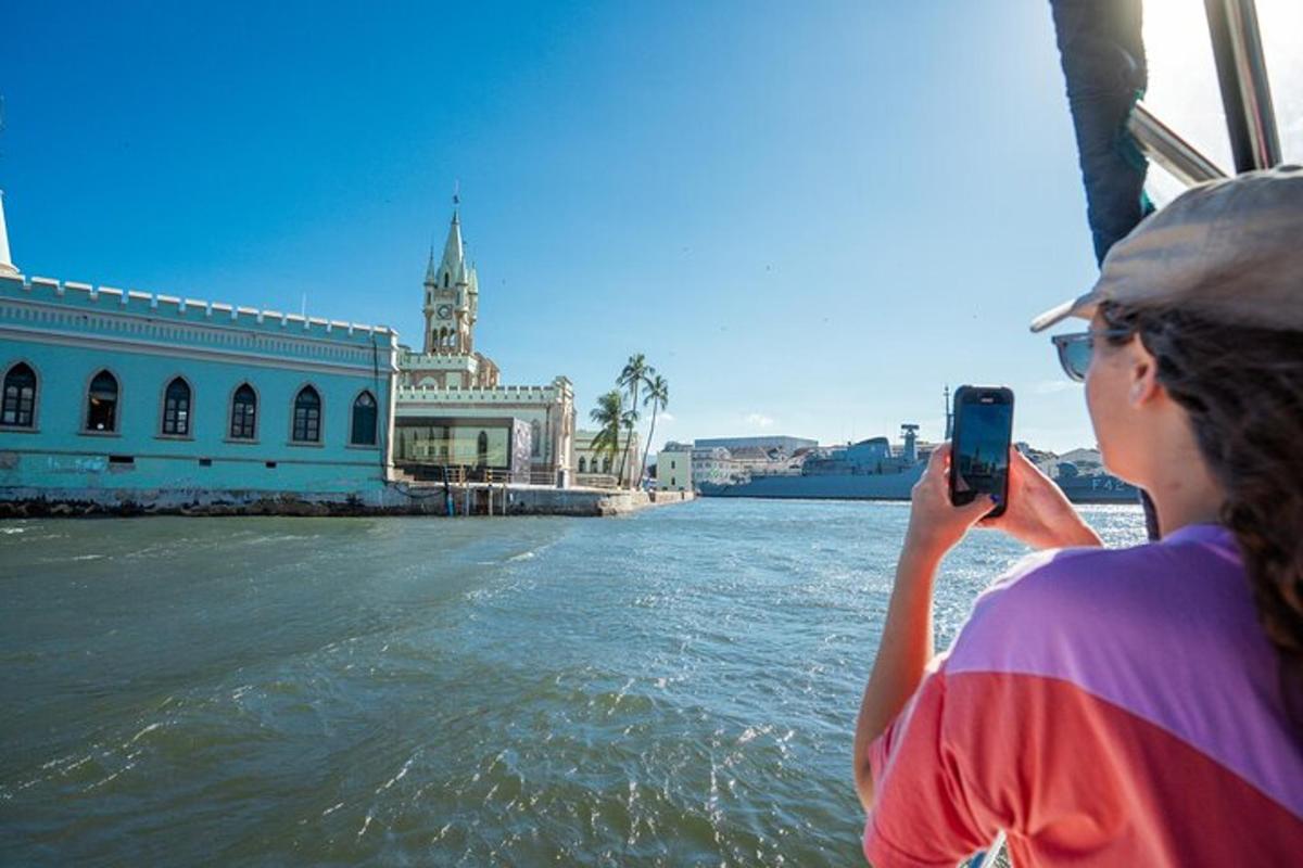 a woman taking a picture of the water from a boat