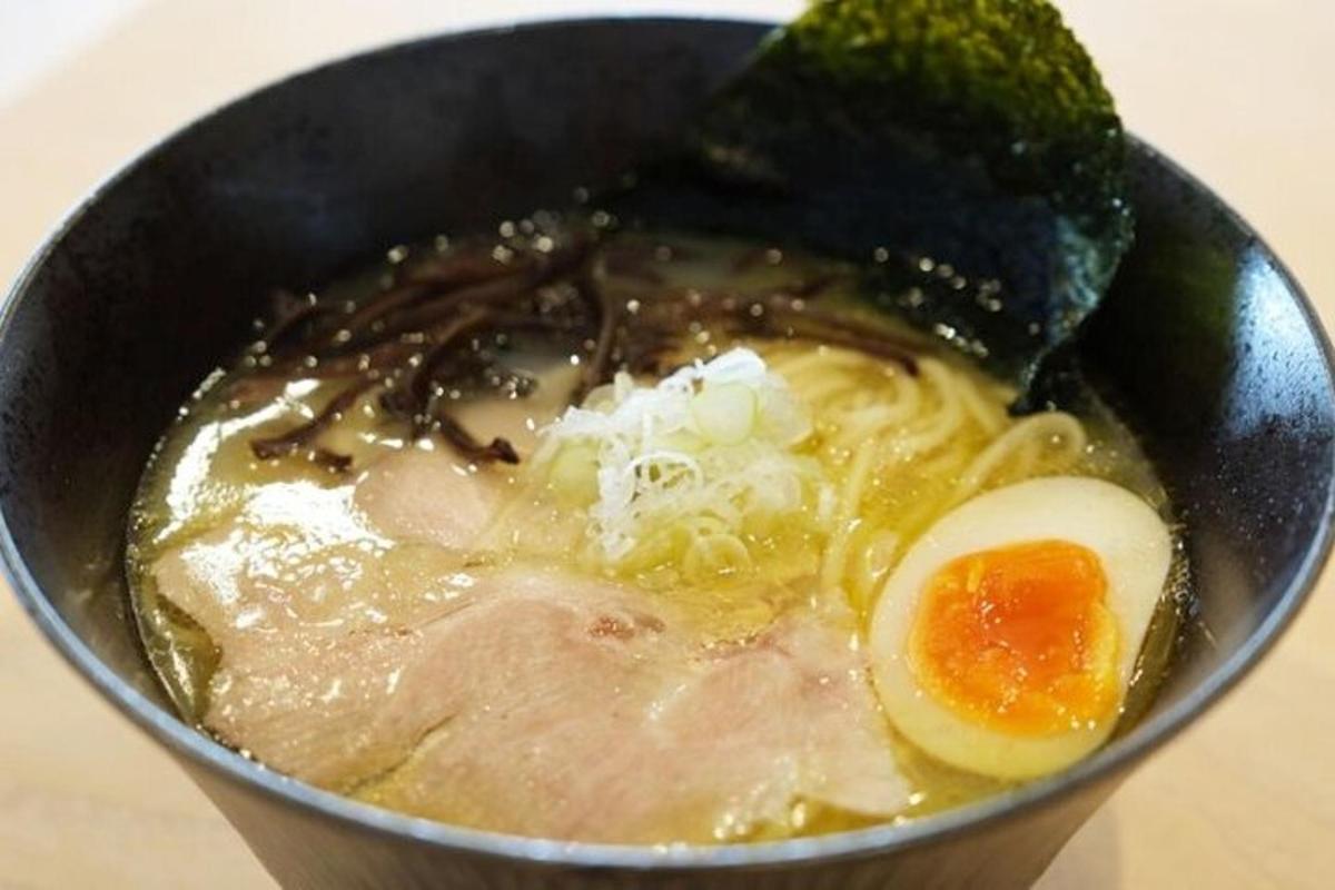 a bowl of soup with an egg and meat