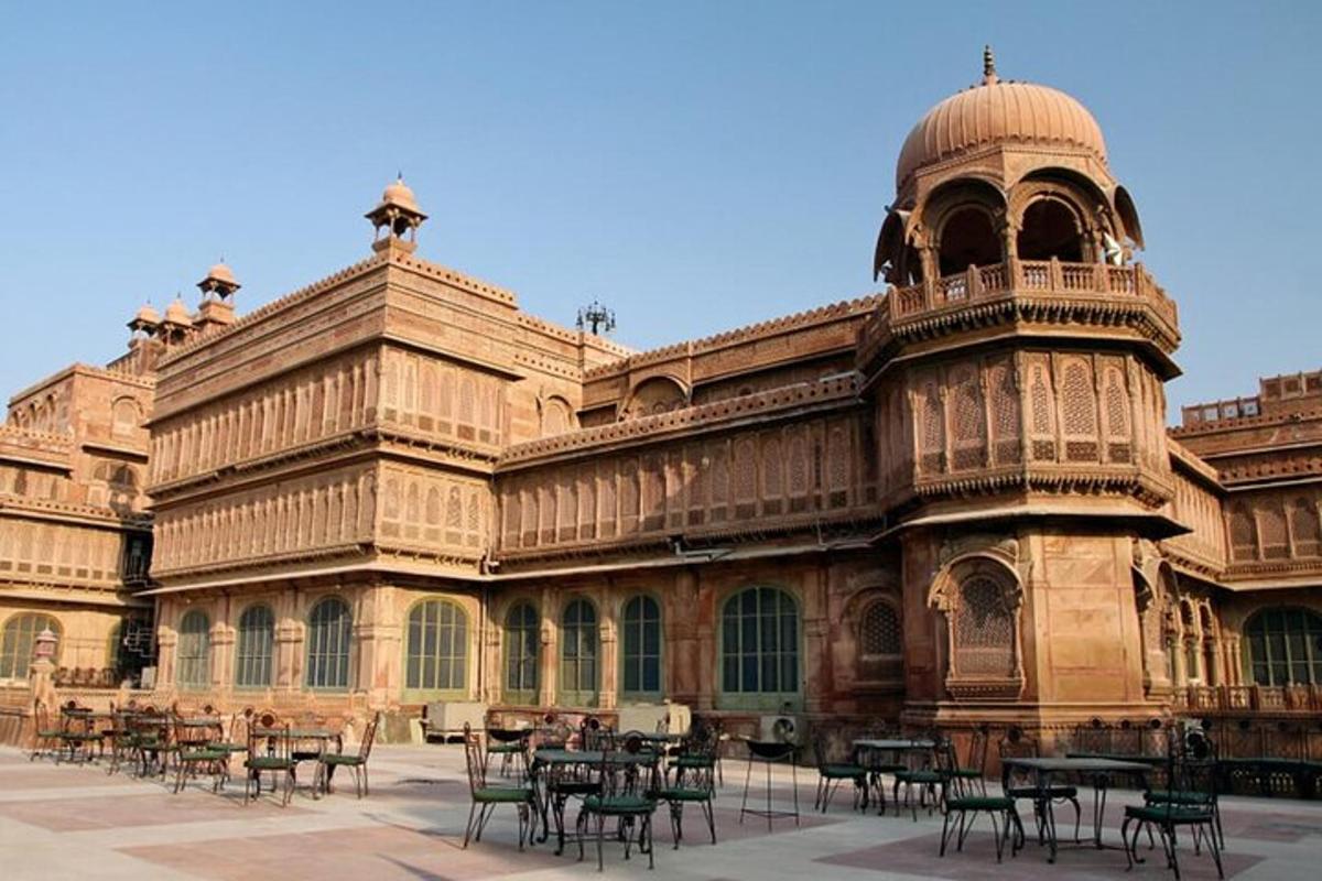 a large building with tables and chairs in a courtyard
