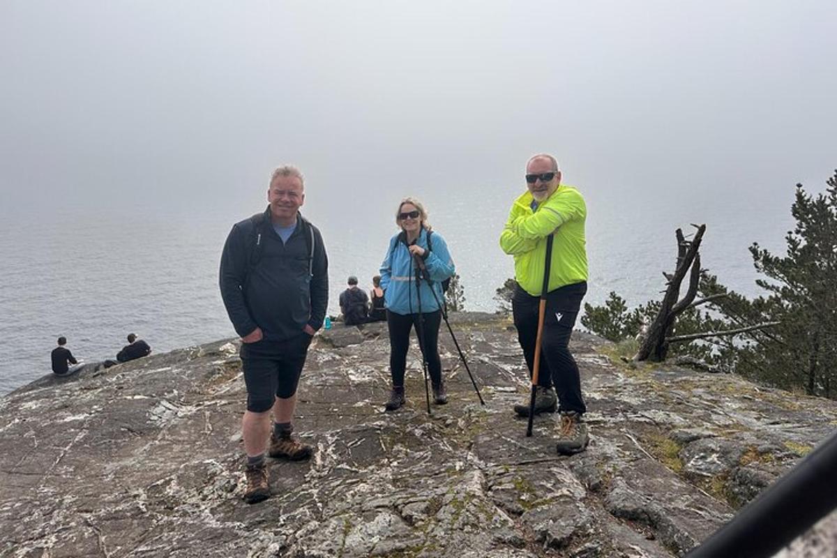 Tres personas de pie en la cima de un acantilado rocoso