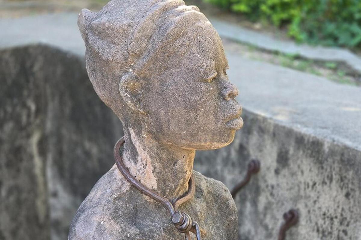 a statue of a boy standing next to a wall