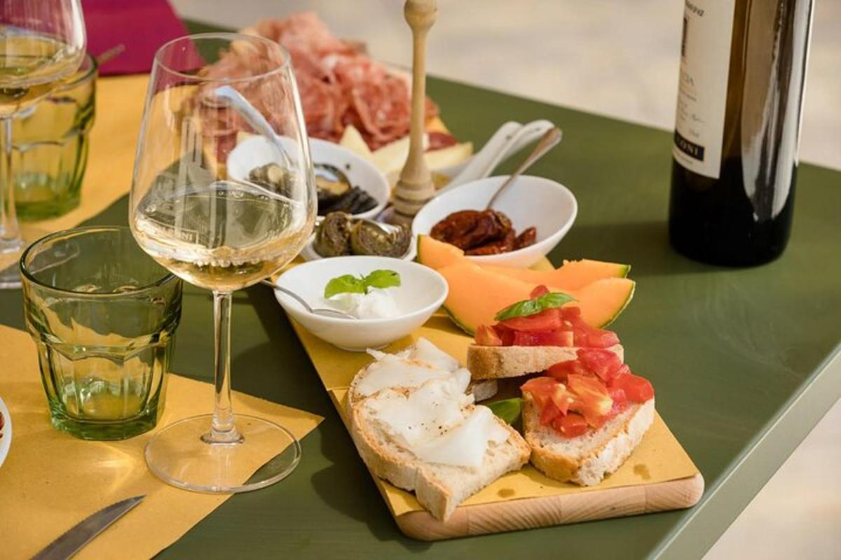 stalas su lėkšte maisto ir taure vyno