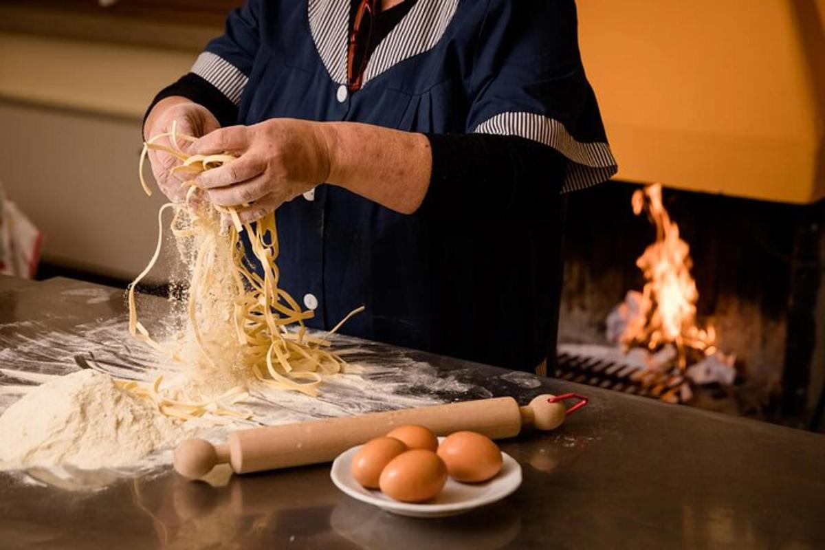 Ein Mann bereitet Spaghetti mit Eiern auf einem Tisch zu
