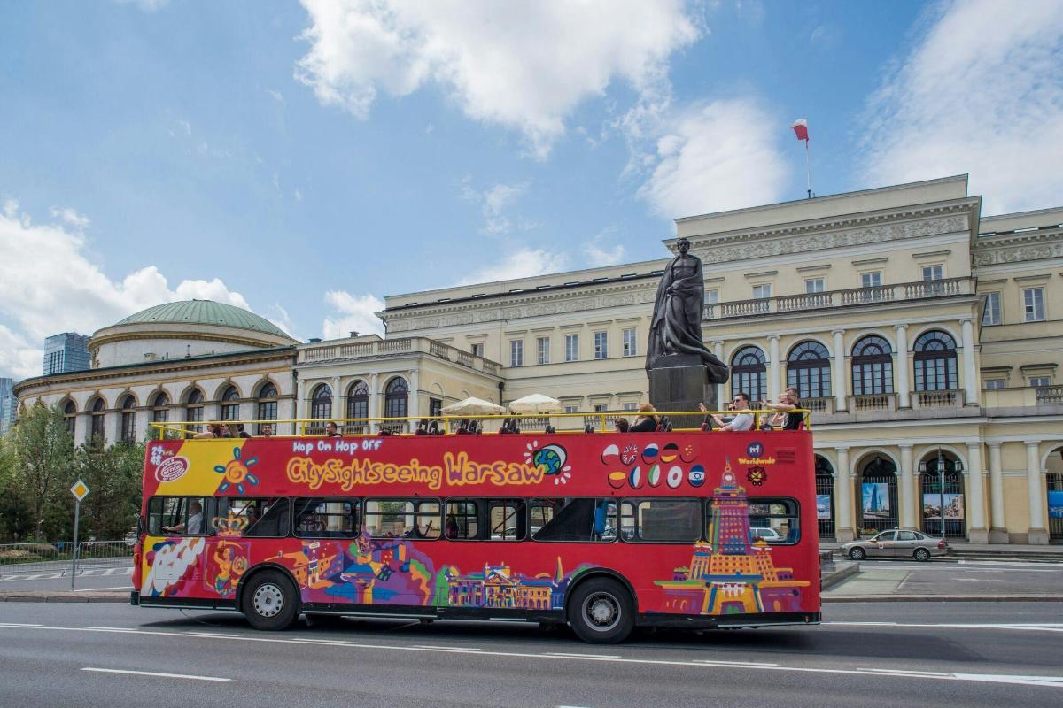 a red double decker bus in front of a building