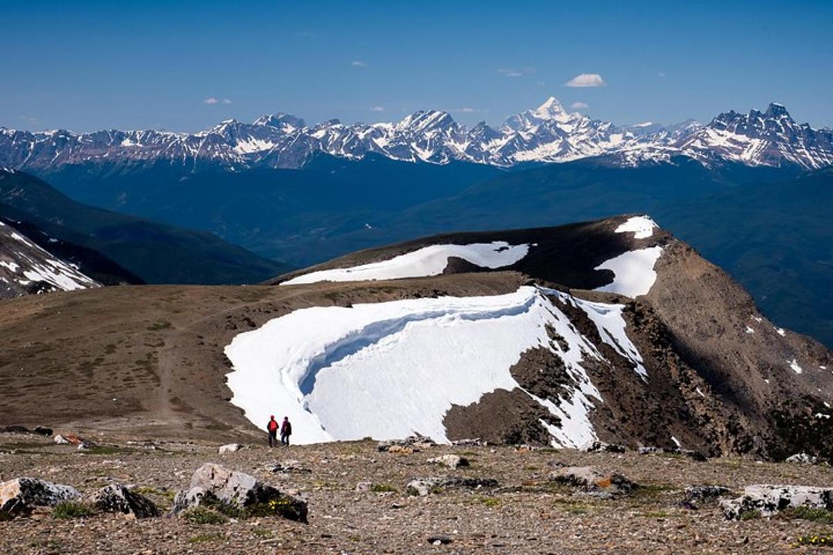 two people standing on top of a snow covered mountain