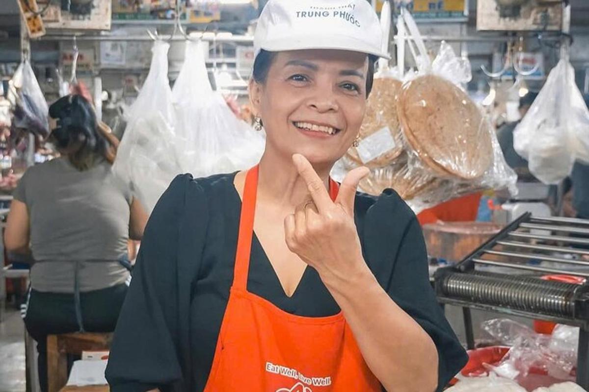 a woman in a kitchen giving the peace sign