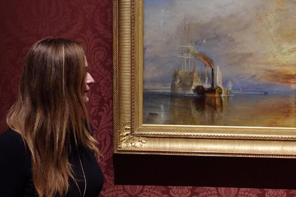 uma mulher parada ao lado de uma pintura de um barco