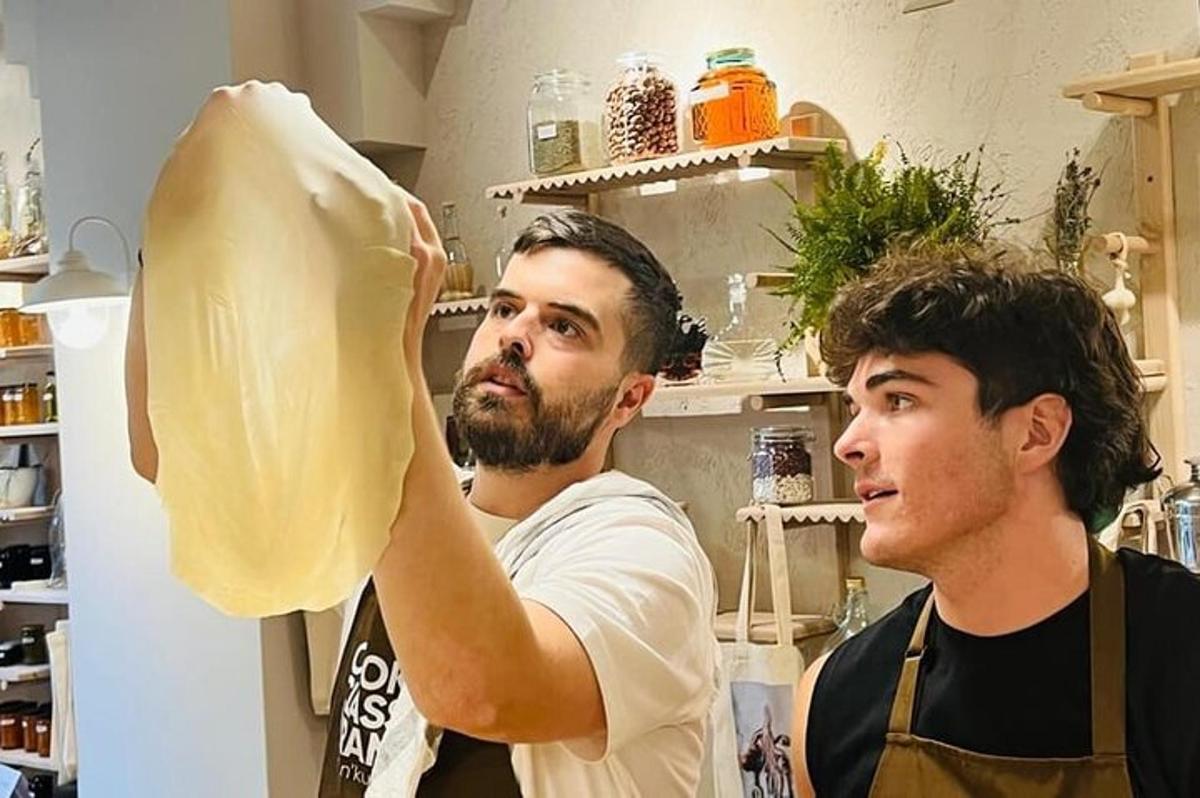 due uomini in cucina che tengono in mano un pezzo di pane