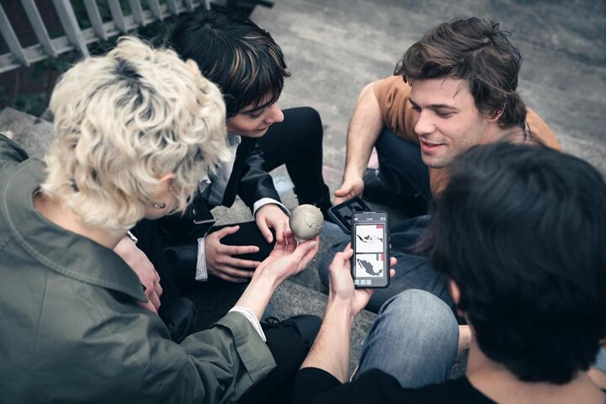Un grupo de personas tomando fotografías de un hombre con un teléfono celular.