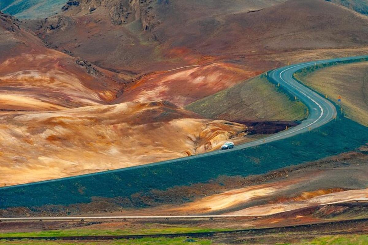 a car driving down a road in the mountains