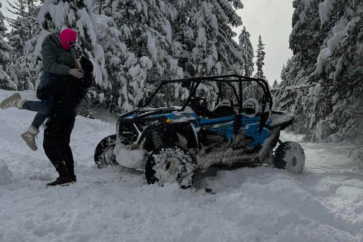 uma pessoa parada ao lado de um quadriciclo na neve