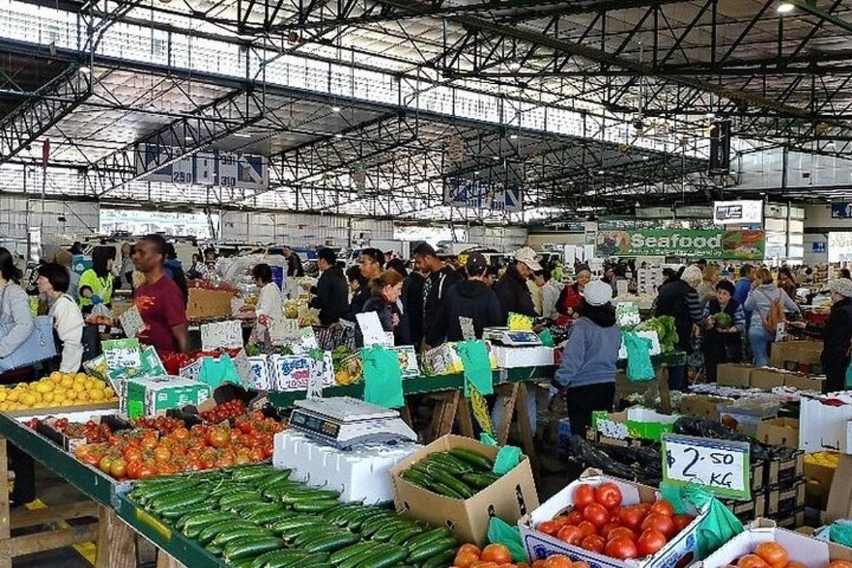 un gruppo di persone in un mercato di frutta e verdura