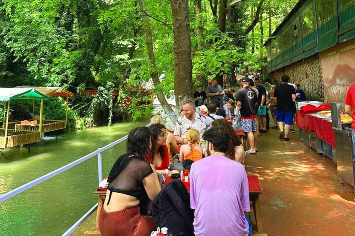 un groupe de personnes assises à une table au bord d'une rivière