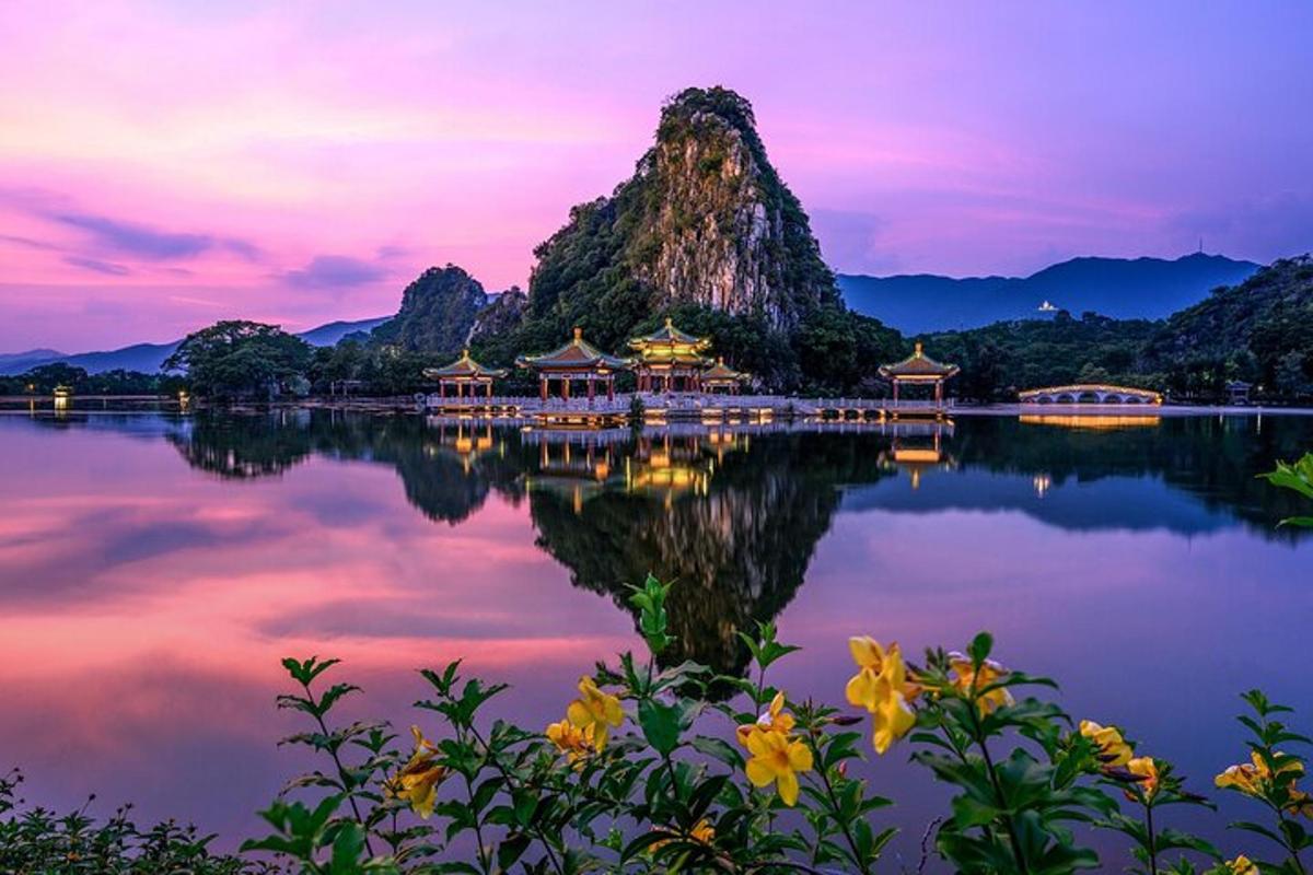 a temple on the water with mountains in the background