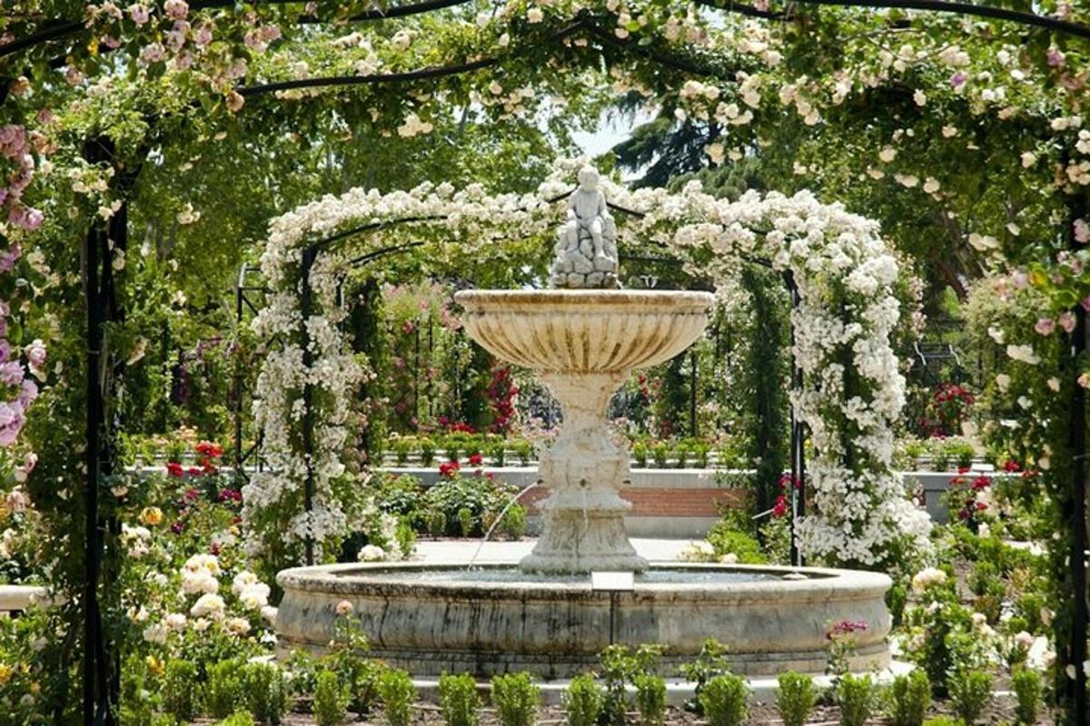 a large fountain in a garden with flowers