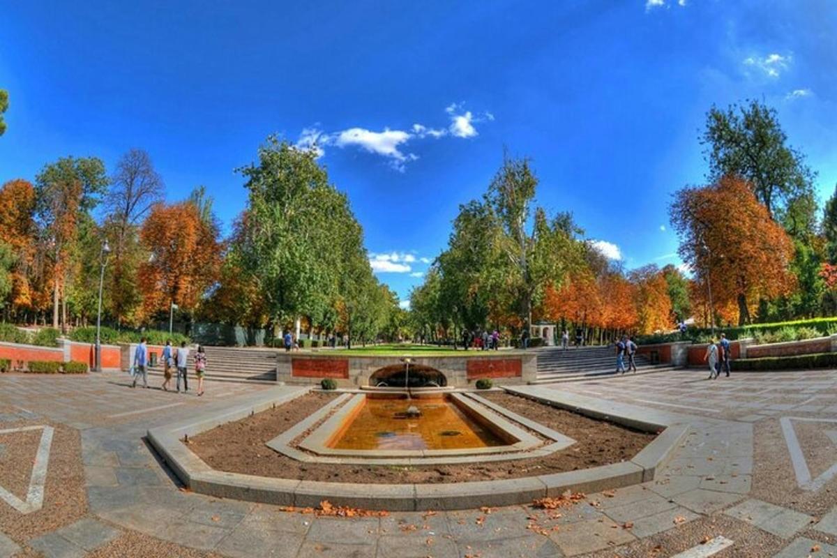 a fountain in a park with people walking around it
