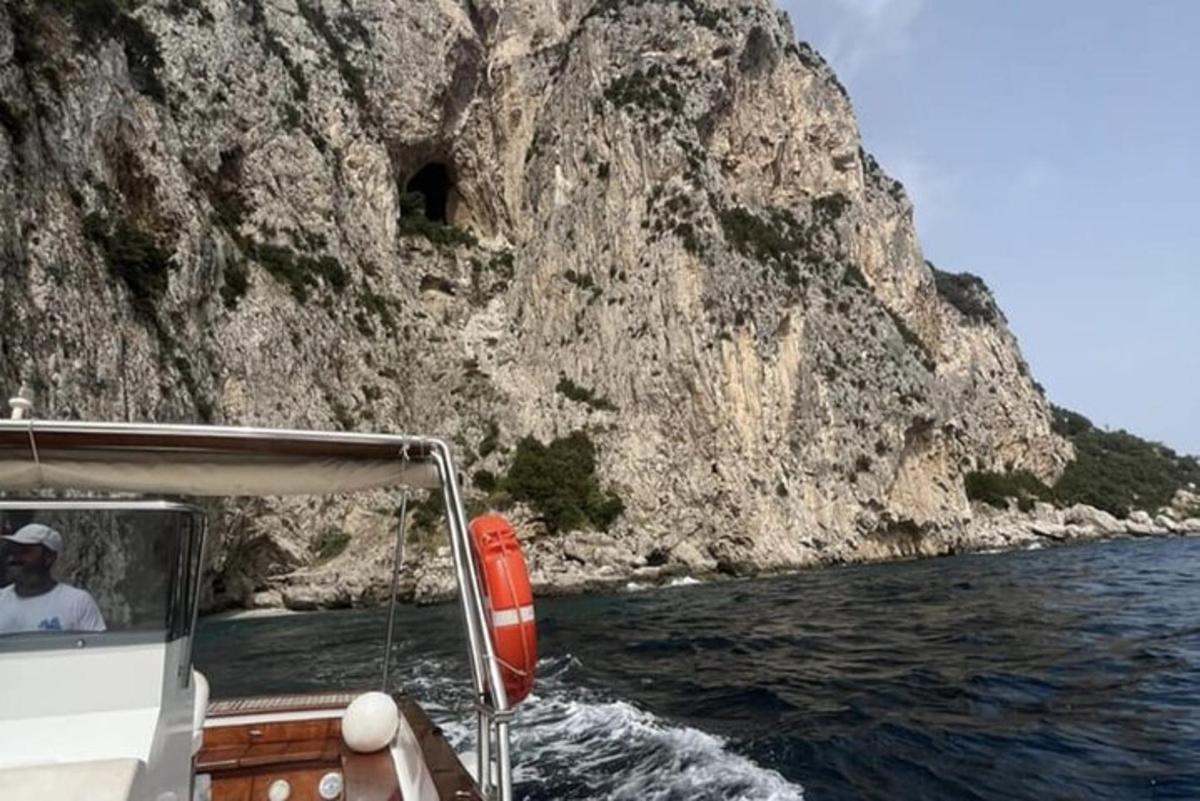 Ένας άντρας σε μια βάρκα στο νερό κοντά σε ένα βουνό